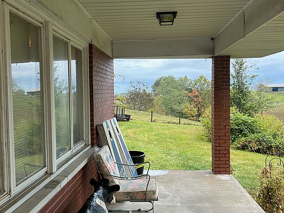 Covered side porch. Perfect for outdoor cooking or relaxing and watching the sunset over the farm behind the house. Enjoy watching the cattle grazing in the fields while enjoying your morning coffee!