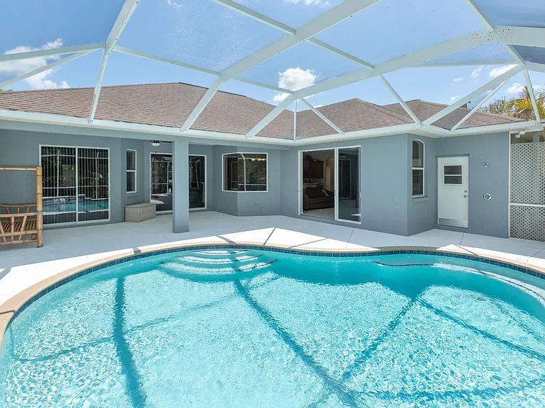 Large outdoor covered patio with screened enclosure and pool recently resurfaced. Child safely gate available. Fenced dog area is just outside the screen door to the right of this photo.