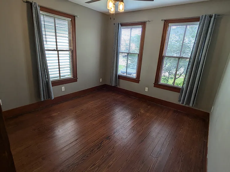Bedroom 1 with original hardwood floors and beautiful windows. Bedroom is 12' x 13' and fits a king bed.