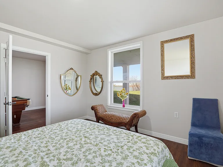 Bedroom four offers the only room with both sunrise and sunset views, overlooking green lawns and one of the rare permanent docks approved over the past 30 years.