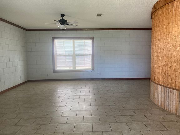 Standing in back at slider door looking toward the front double windows. Large open space with room for dining table and chairs, sofa, chairs, coffee table and TV