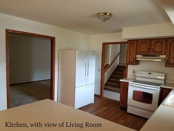 Kitchen with view of livingroom and steps to upstairs.