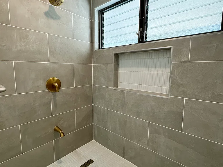 Primary bath shower. Beautiful tile and gold fixtures.