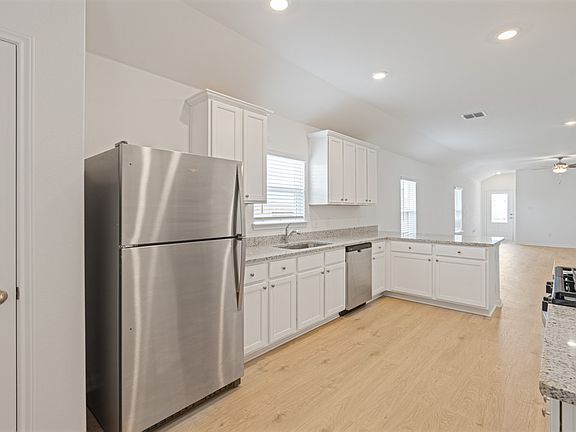 Enjoy stunning granite countertops and designer wood cabinetry in this kitchen.