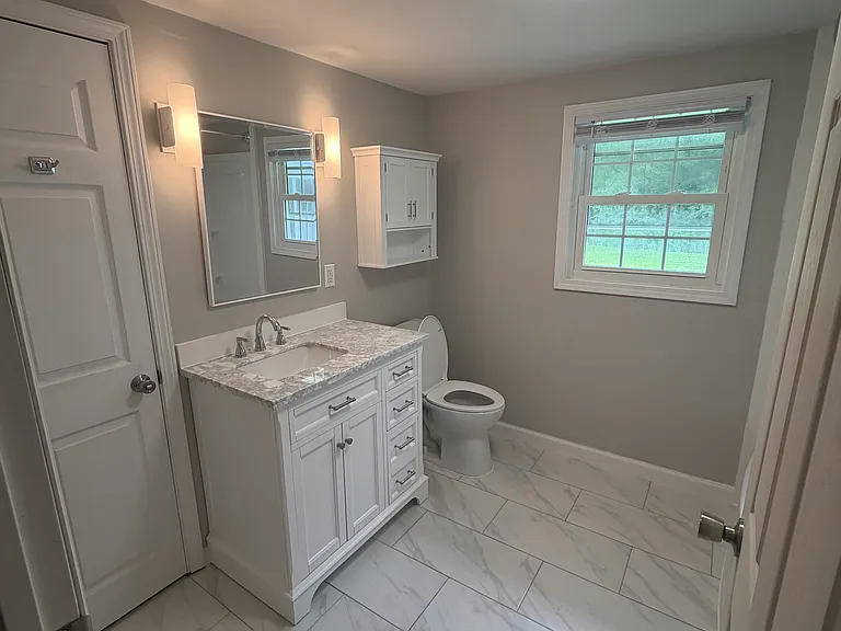 new bath with ceramic tile, new vanity and new rounded tub