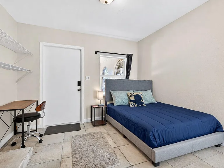 Bedroom with full bed, private entrance, work space and wall-mounted television