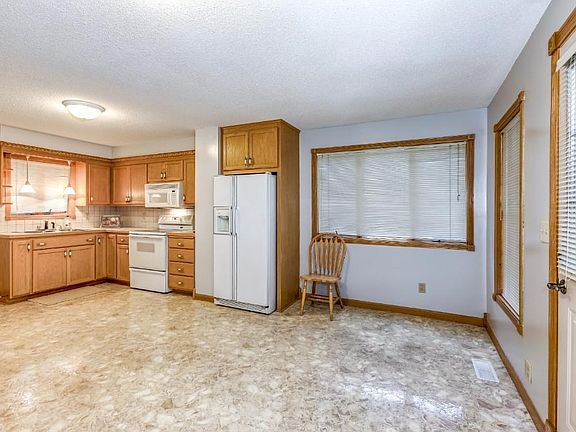 Hardwood trim in enclosed front entrance with large windows and overhead lighting.
