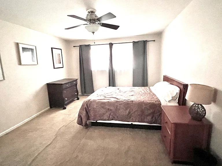 Bedroom with queen bed (sheets and comforter included), dresser, night stand, a night lamp, pictures and blackout drapes