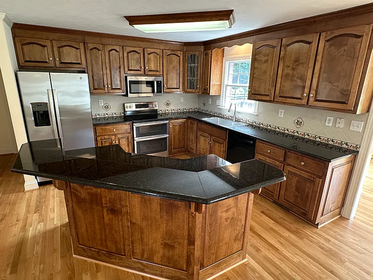 Kitchen with granite countertops, stainless appliances and breakfast bar