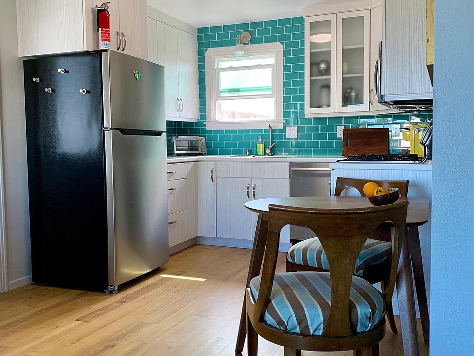 Remodeled kitchen with new appliances, cabinets, and floors. Daytime.