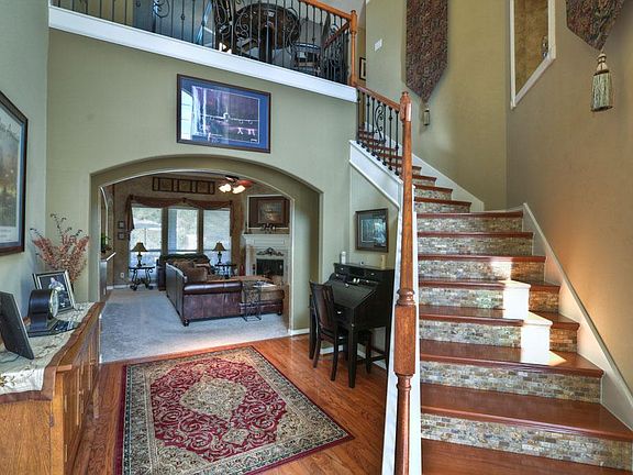 The staircase is a focal point! Wood steps, tile risers + iron balusters.