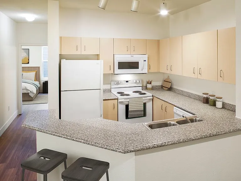Classic Package I kitchen with oak cabinetry, laminate countertops, white appliances, and hard surface flooring