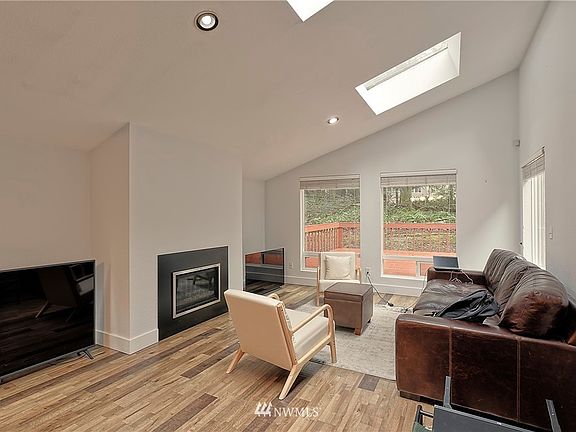 Family room with fireplace, skylights and large picture windows.