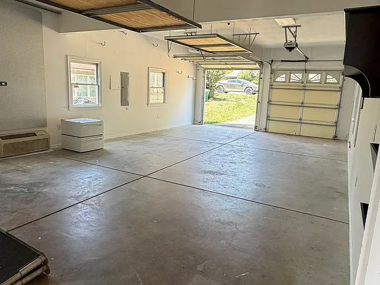 Spacious two-car garage with high ceilings, offering room for vehicles plus flexible storage or workshop space.