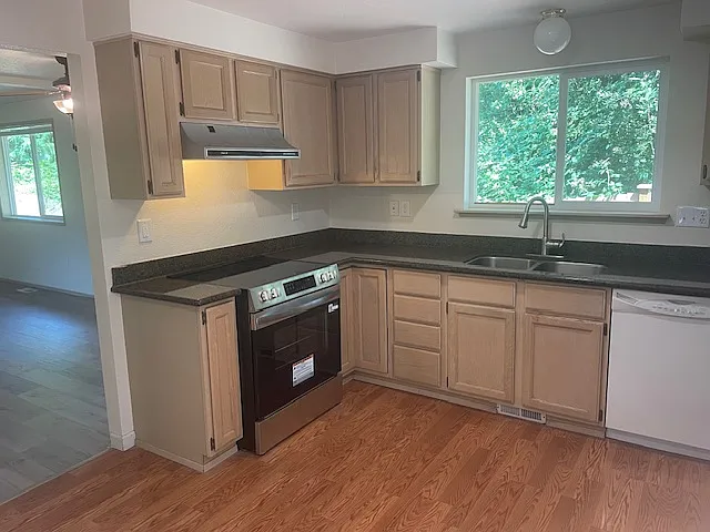 Kitchen with granite countertops, new stove and refrigerator.