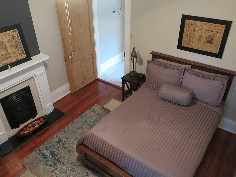 Super comfortable and cozy bedroom with original fireplace and salvaged newsprint found under three layers of linoleum floors!