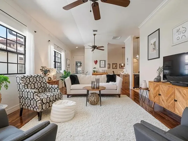 Awesome open living room with high ceilings and lots of windows, wonderful light and bright with ceiling fans.