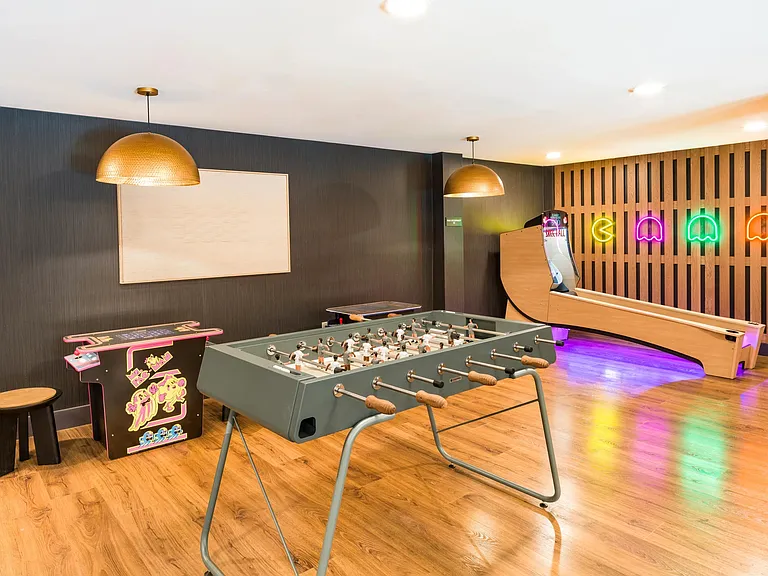 A vibrant game lounge at Modera Higley Commons, blending retro-inspired details and inviting spaces designed for relaxed competition and connection.