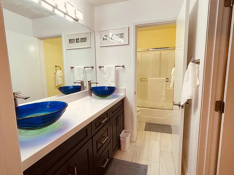 Second en-suite bathroom with beautiful double sink vanity, tiled floor and lighting