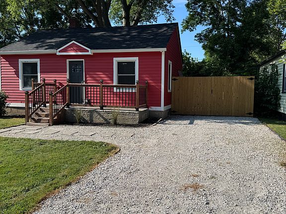 Driveway with privacy fence that opens fully with secure storage behind for a vehicle.