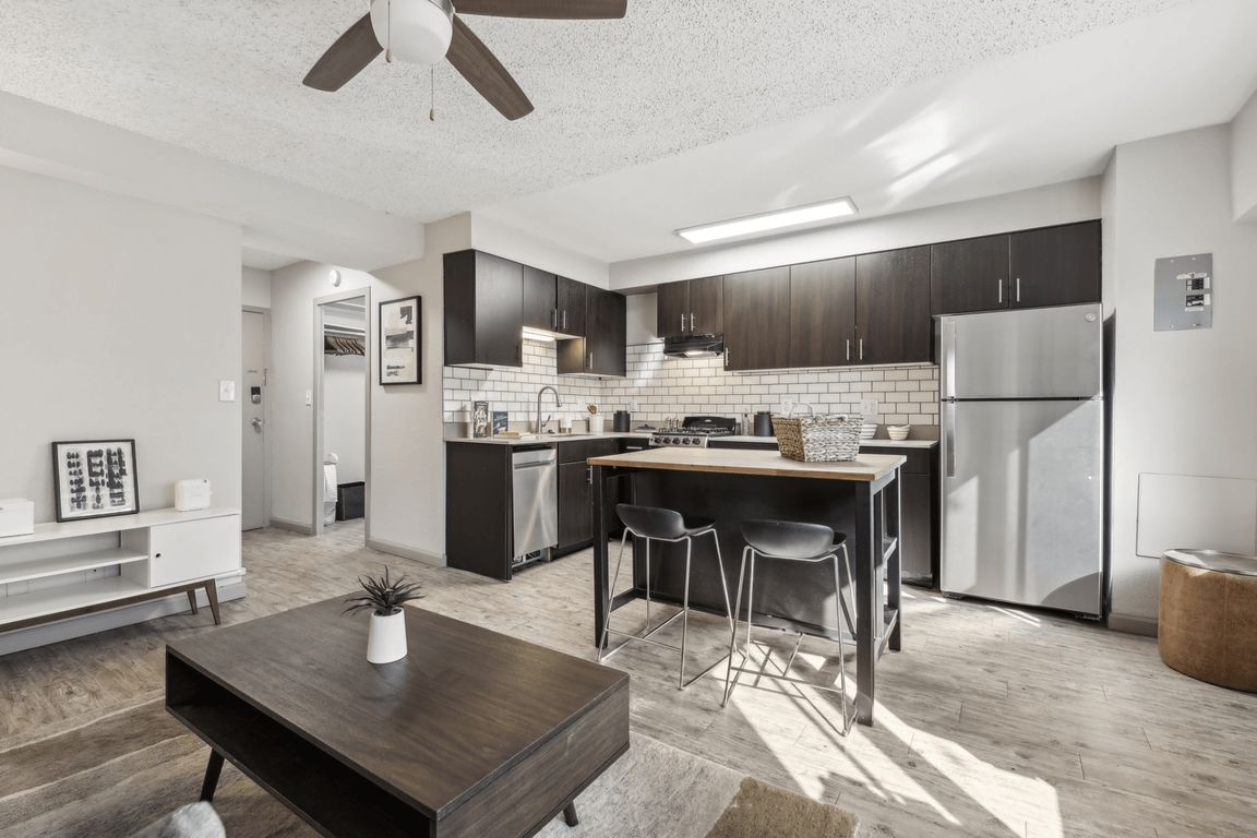 The kitchen area is updated for a modern look with dark wood cabinets and updated appliances