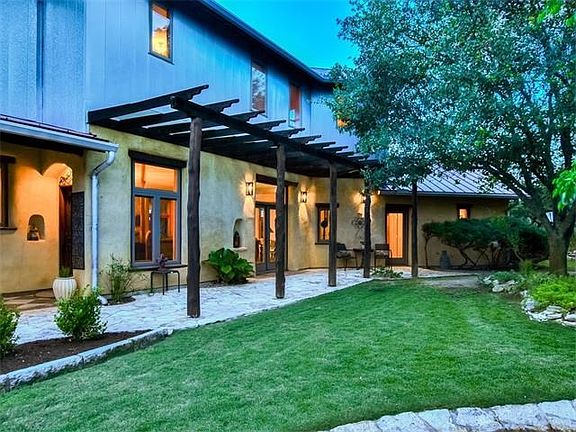 This courtyard enjoys hillside garden views with stone steps that wind up to a raised bed vegetable garden.