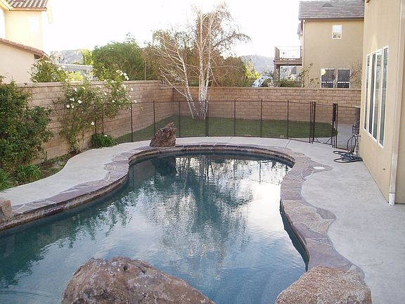 Fenced off pool with grass area