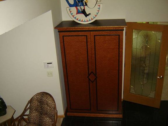 Custom Italian wood armoire in front entry stays.