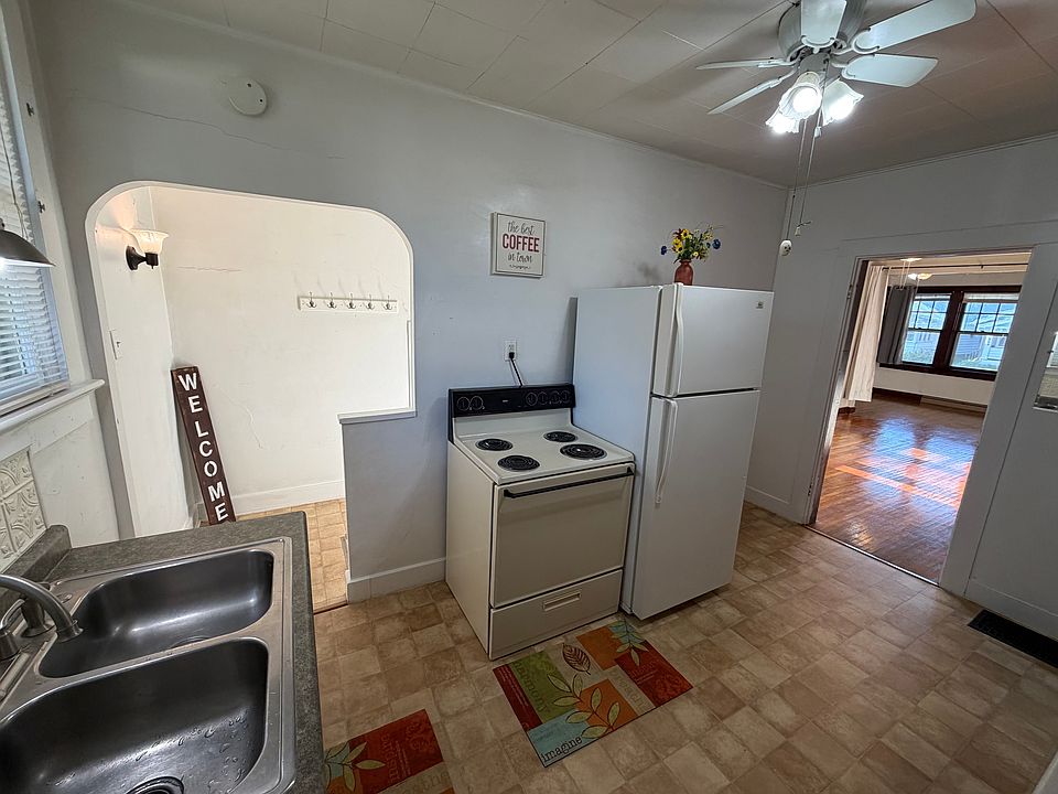 kitchen, doorway to living room on right, stairway to side door, bathroom and basement bonus room on left
