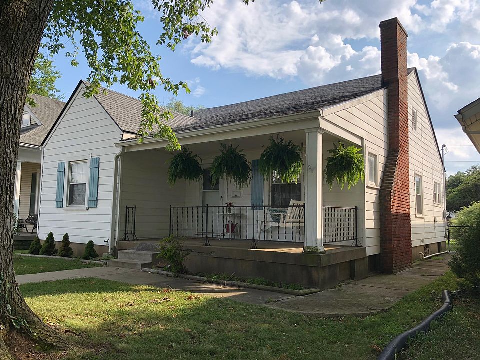 Cute cottage-style home with front porch swing on quiet street.
