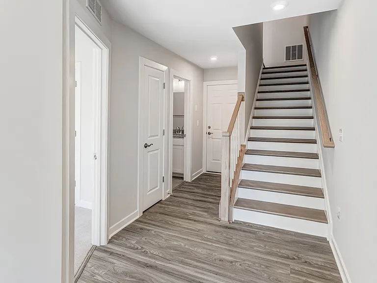 Ascend the hardwood staircase to the heart of the home, an inviting open-concept main level that seamlessly connects the kitchen, dining, and living spaces.
