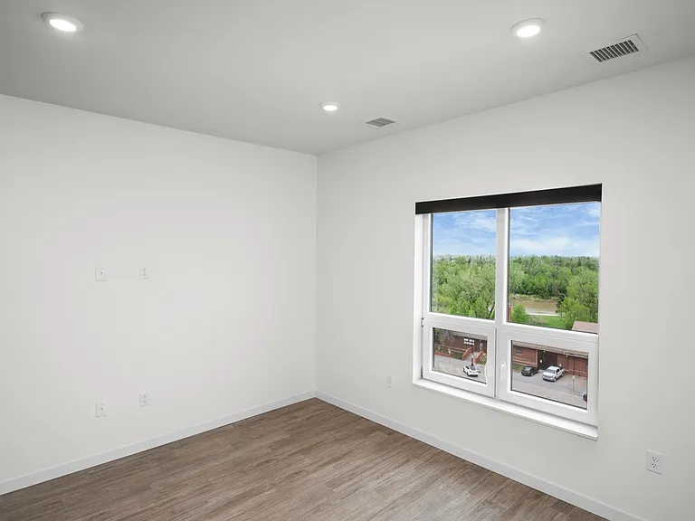 Bright and modern room with a large window showcasing a scenic view, featuring sleek hardwood floors and recessed lighting. Bright and modern room with a large window showcasing a scenic view, featuring sleek hardwood floors and recessed lighting.