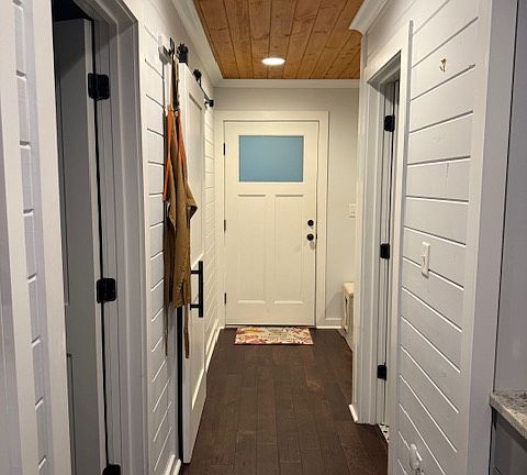 Main floor hallway to mudroom, full bathroom, bedroom, and hall closet.