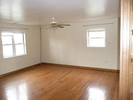 Open concept Livingroom, hardwood floors, plenty of natural light, with ample space for furniture. Ceiling fan and window air conditioner.