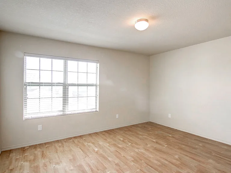 Bright, empty room with large window and sleek wood flooring, ideal for personal customization and abundant natural light. Bright, empty room with large window and sleek wood flooring, ideal for personal customization and abundant natural light.