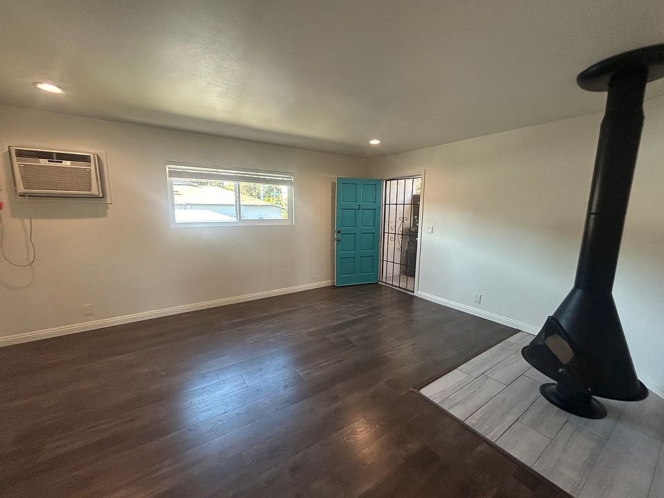 Living area including fireplace with view towards front door
