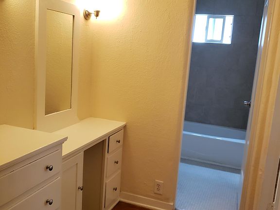 Walk in closet showing vanity and bathroom entry