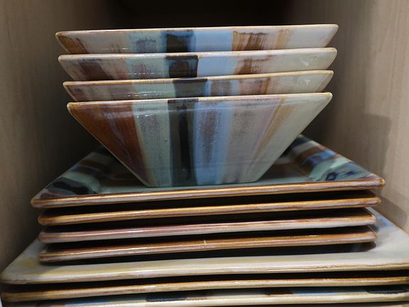 Kitchen includes plates, mugs, flatware, and glasses.