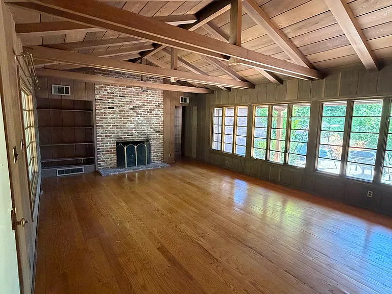 Living space with built in bookcase, nice large windows and view of backyard and patio