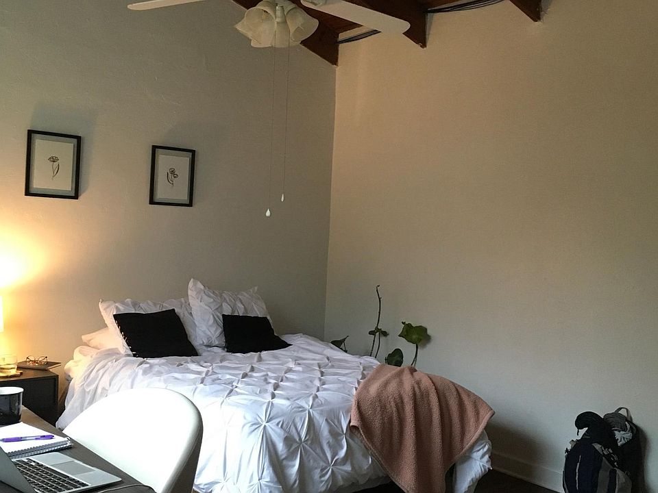 Upstairs bedroom with vaulted ceiling and ceiling fan