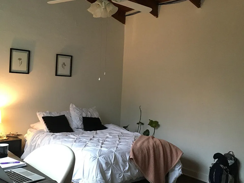 Upstairs bedroom with vaulted ceiling and ceiling fan