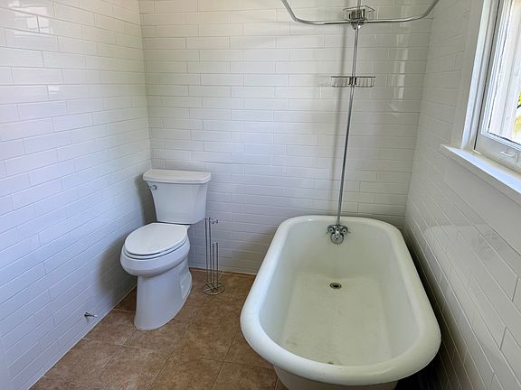 New toilet and tile surround. The tub is original to the property.
