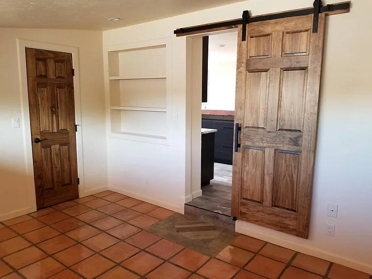 Large bedroom with custom wood doors and tile. Cool built-in storage. LED cans.
