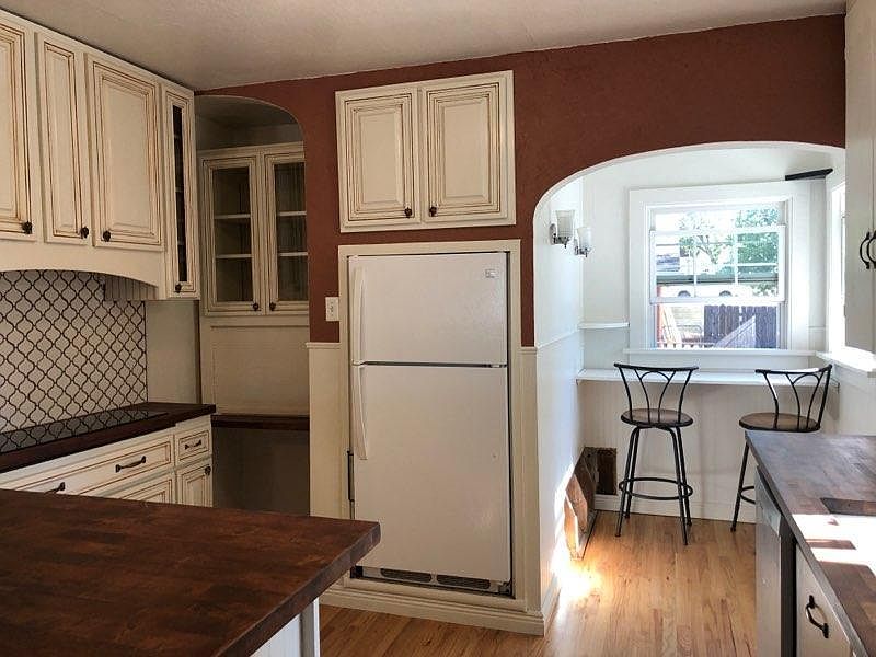 Kitchen updated with backsplash, induction stove, new fridge, butcher block countertops, new oak floors and WAY more cupboards.