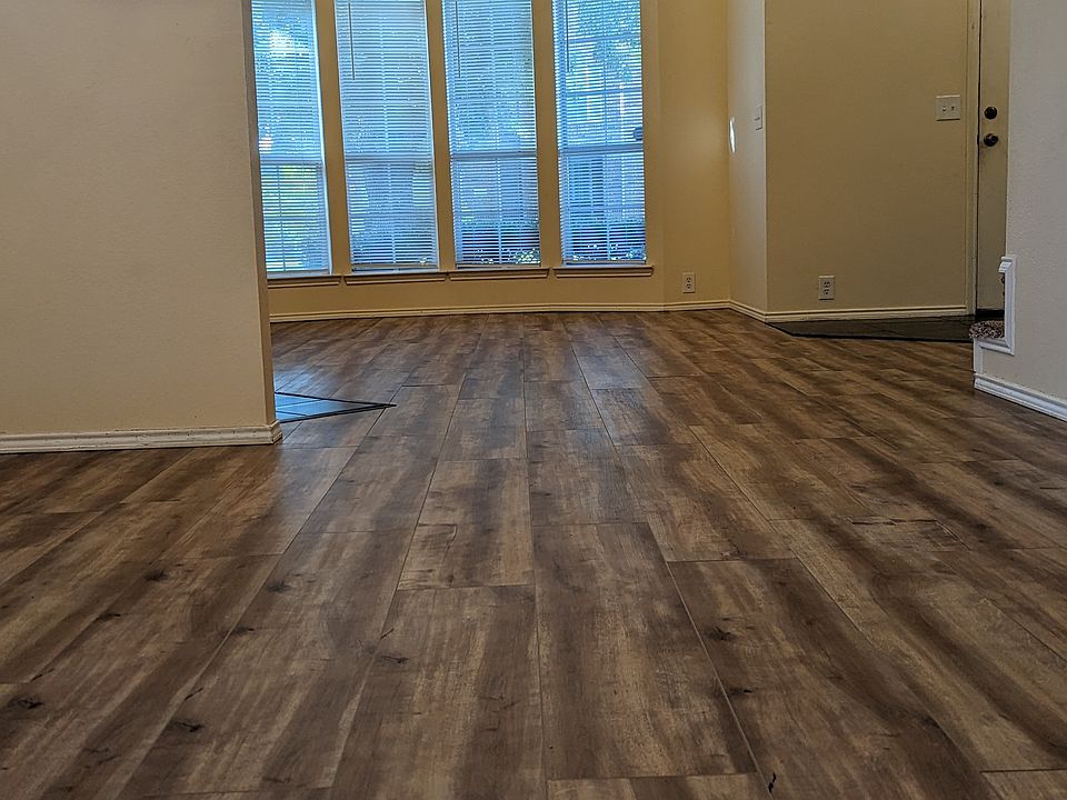 Spacious and high ceiling living room with dark wood flooring and ceiling fan