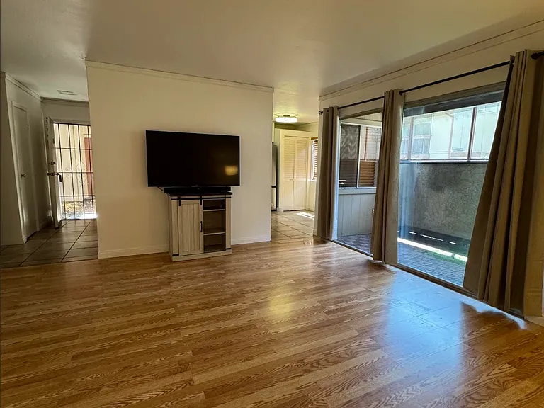 Living room facing South. Patio window faces west. Television and stand not included.
