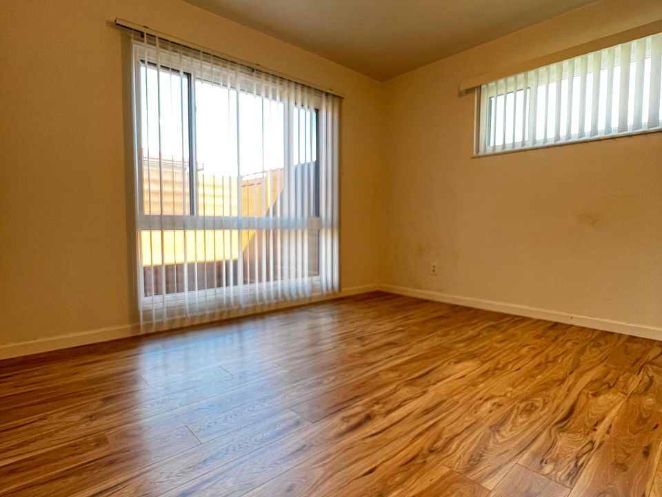 Large bedroom with newer laminate flooring, ceiling fan and plenty of natural light.