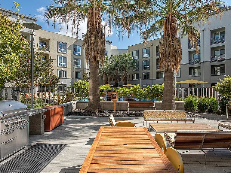 Outdoor dining courtyard featuring modern furnishings and landscaped views at Aster Apartments near BART.