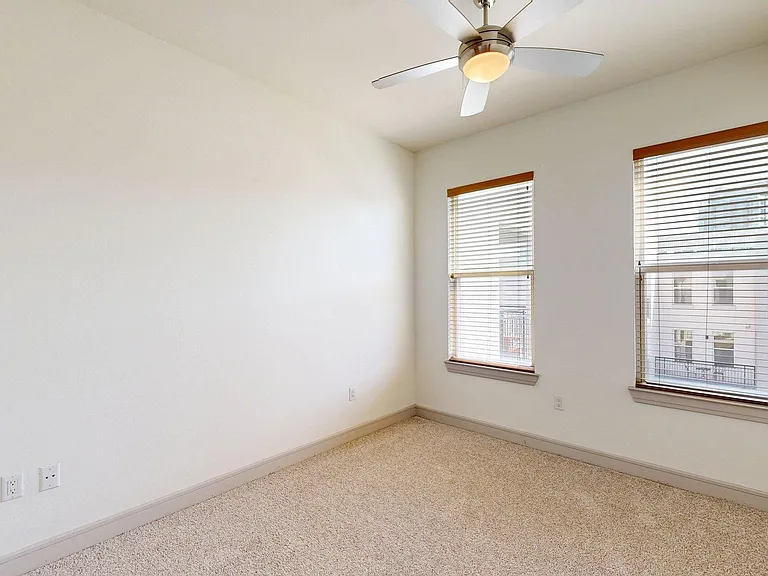 Griffis Uptown spacious apartment bedroom with carpet floor.