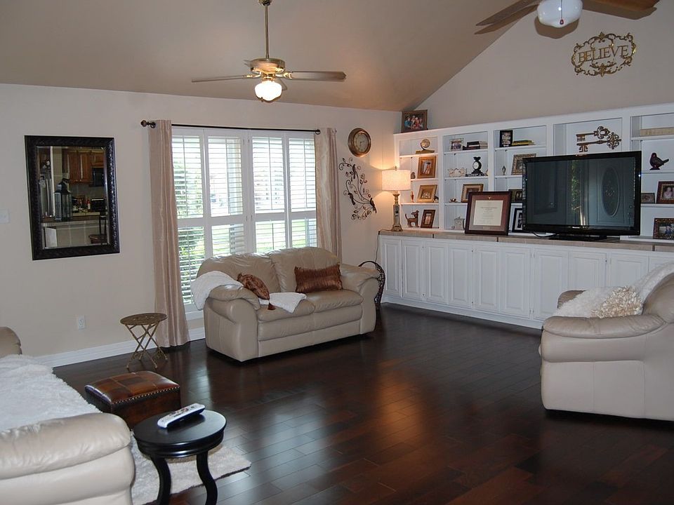 Living room with wood floors, white built-in cabinets, tall ceilings.